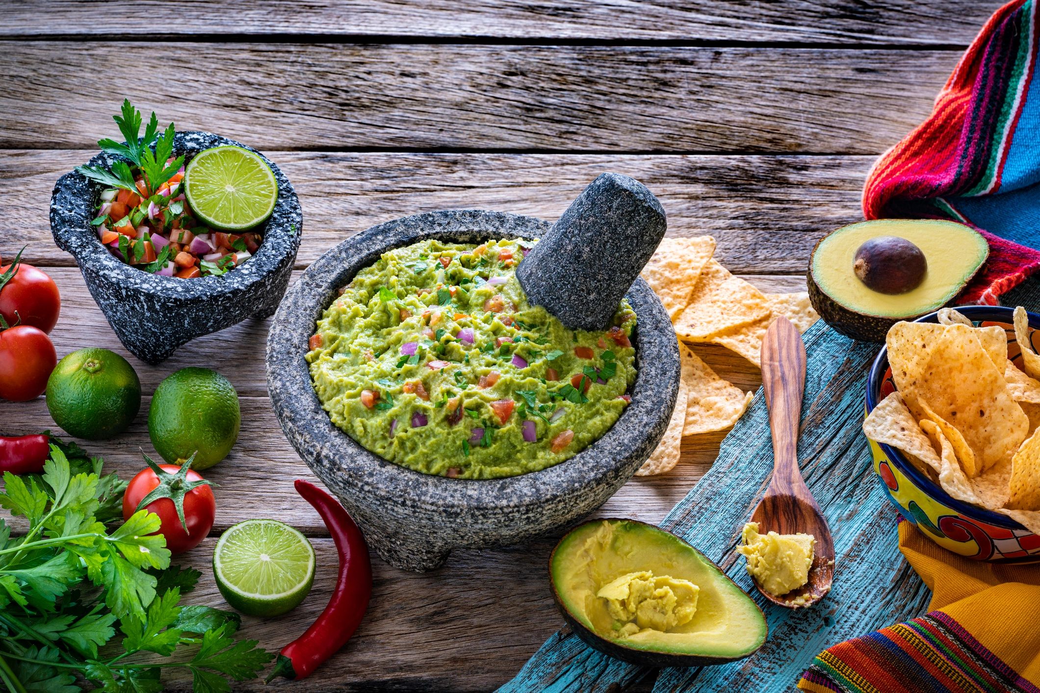 Guacamole with ingredients and tortilla chips